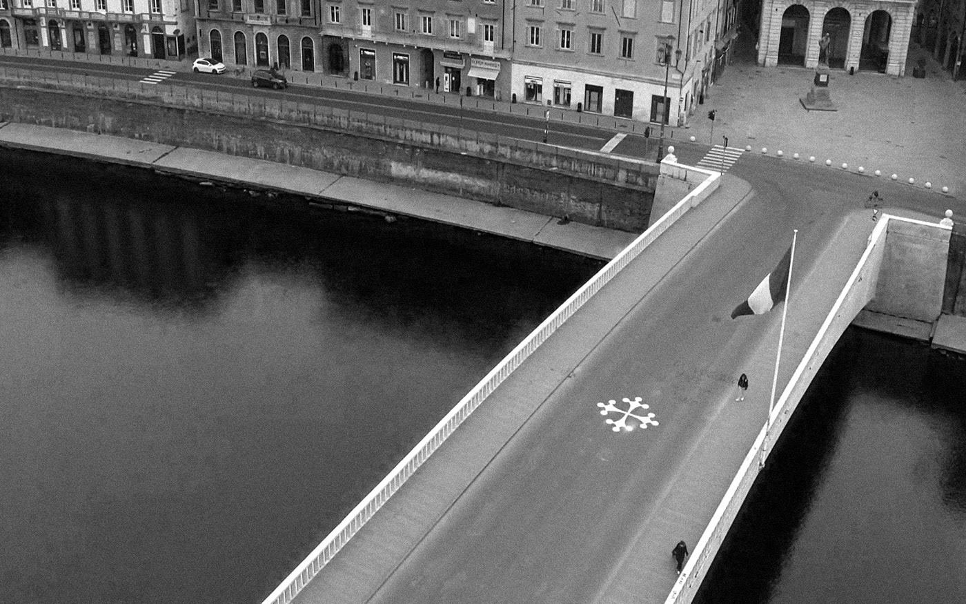 14. kép: Két magányos alak sétál az Arno folyót átszelő Mezzo-hídon, a híres pisai ferde torony közelében.