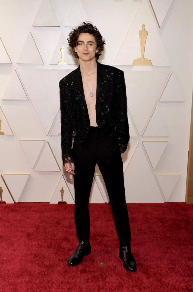 Timothee Chalamet Louis Vuitton szerelésben érkezett az idei Oscar-díjátadóra, azonban ing helyett csak pár nyakláncot vett fel a flitteres blézere alá.