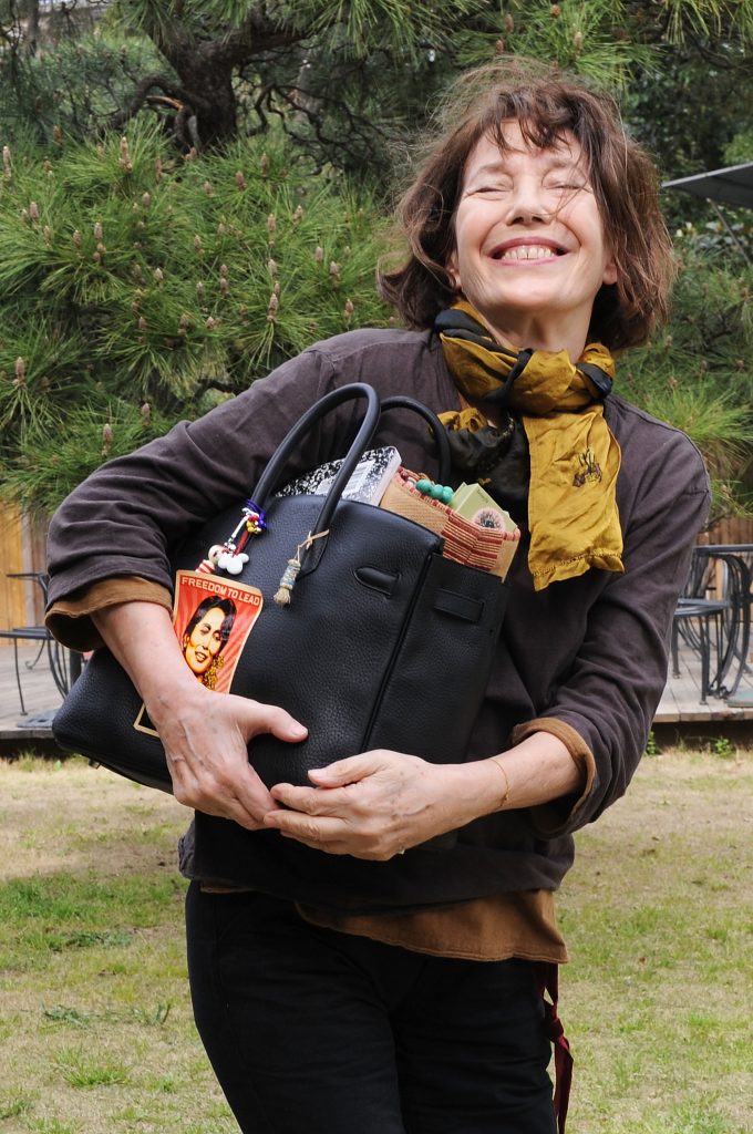 Jane Birkin, kezében egy tömött Hermès Birkin táskával