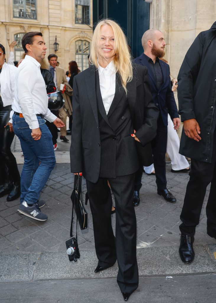 Pamela Anderson fekete nadrágkosztümben a párizsi divathéten