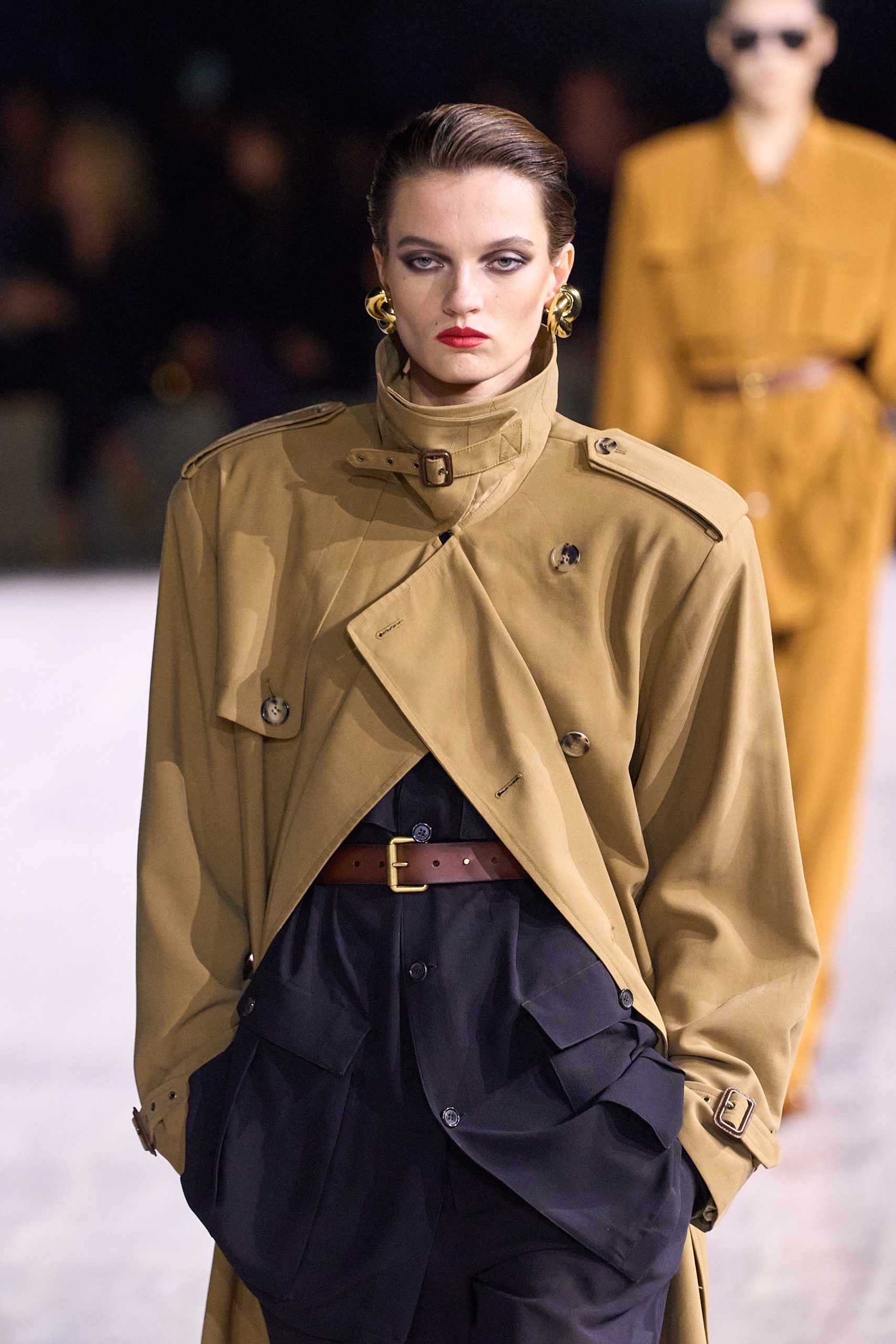 Modell arany színű retro fülbevalót visel a Saint Laurent kifutón