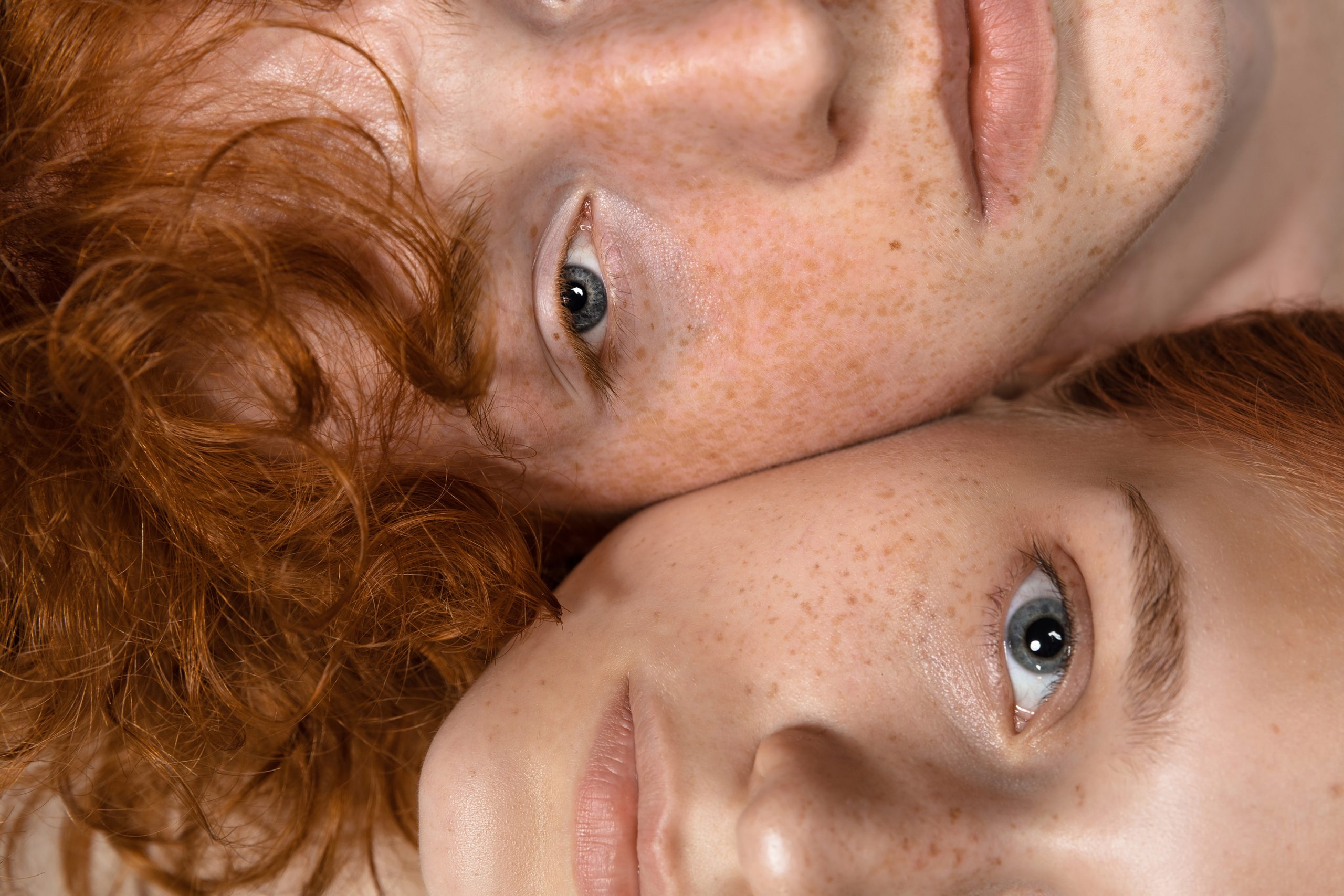 Egy vörös hajú fiú és egy vörös hajú szeplős lány egymás mellett fekszik