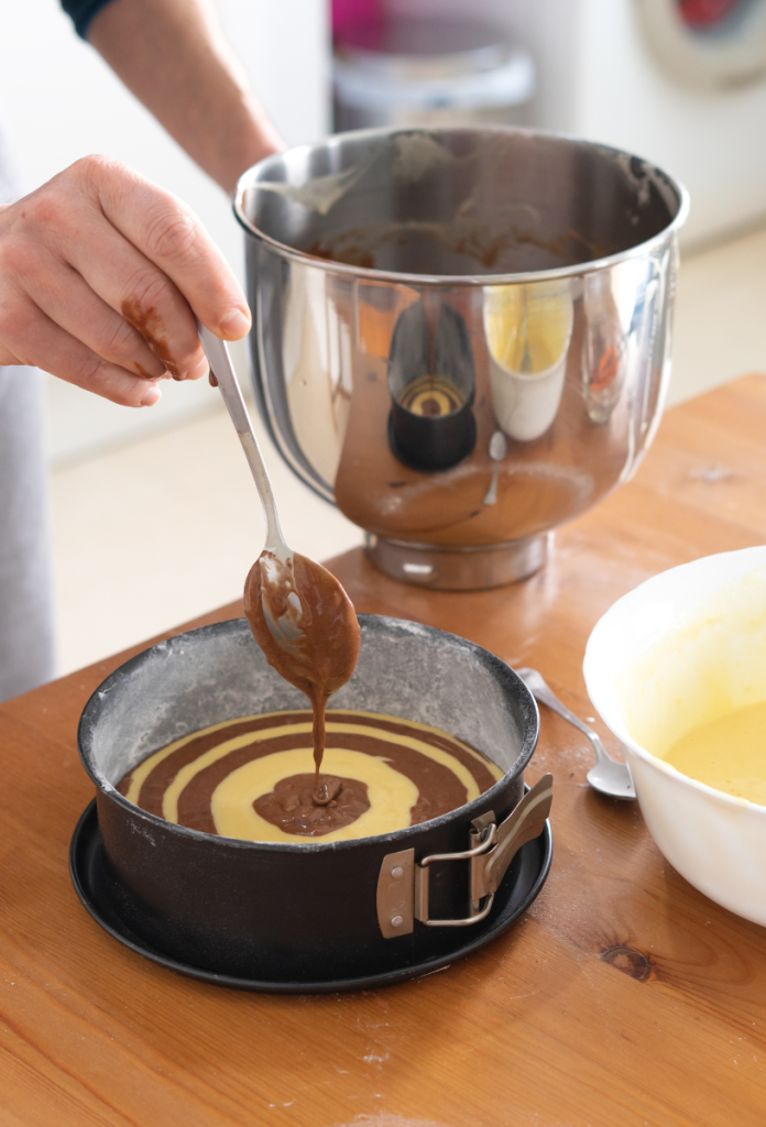 liszt-es-cukormentes-zebra-sutemeny-elkeszitese | Marie Claire A liszt- és cukormentes zebrasüteményhez a barna és sárga tésztát felváltva kanalazzuk a formába