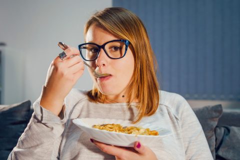 Szemüveges nő tésztát eszik