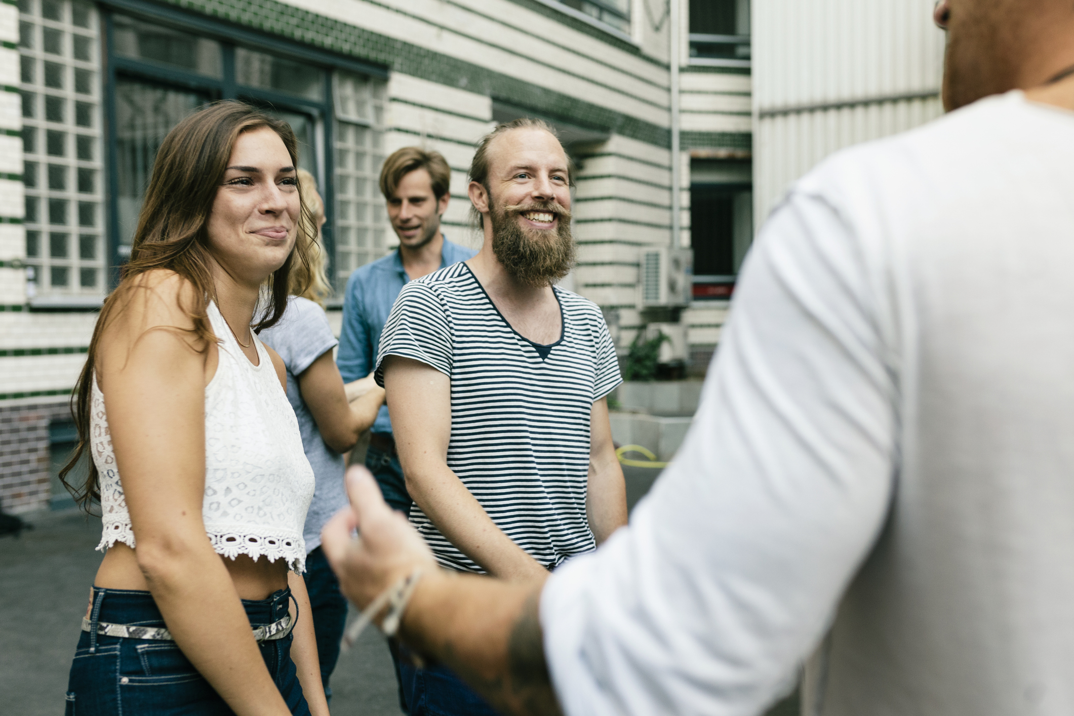 Fiatalok örömmel üdvözlik egymást találkozásnál egy társaságban