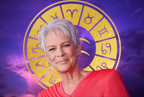 Jamie Lee Curtis piros ruhában lila háttér és a csillagjegyek előtt