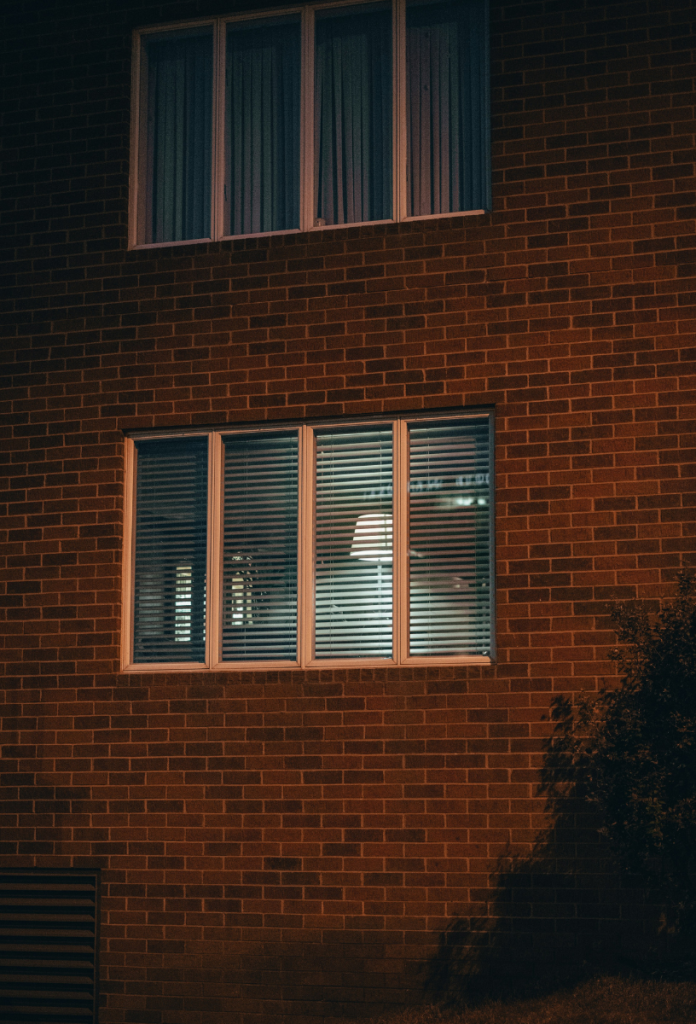 Este egy téglafalú házban kiszűrődik az ablakon át a lámpa fénye