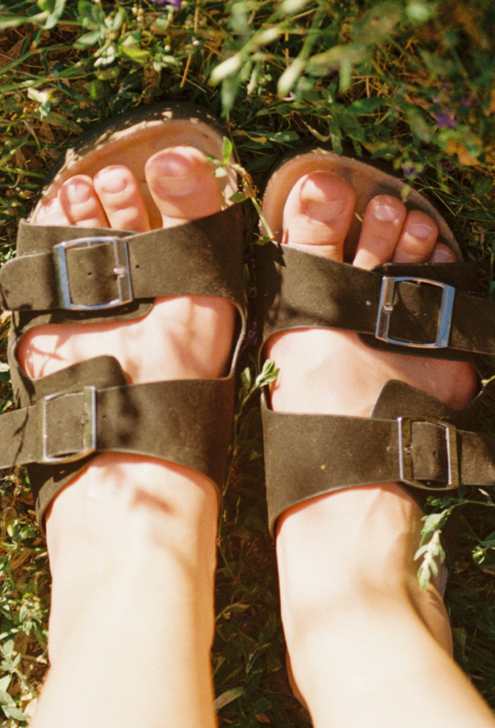 Női lábfej Birkenstock papucsban fűben