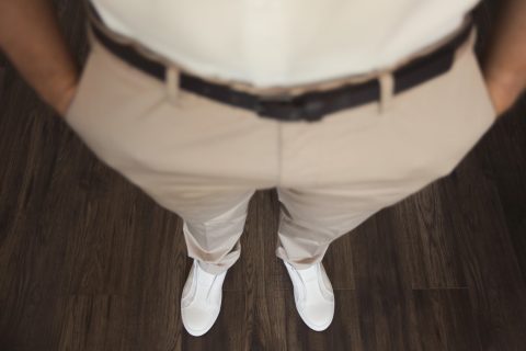 Férfi fehér ingben és nadrágban, fehér cipővel