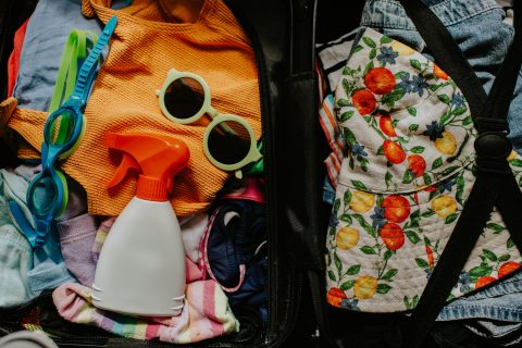 Nyári gyerekes strandolás kellékei: napszemüveg, naptej, kalap, törölköző