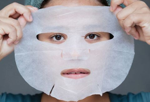 Nő fátyolmaszkot tart az arca elé