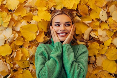 Boldog nő fekszik az avarban