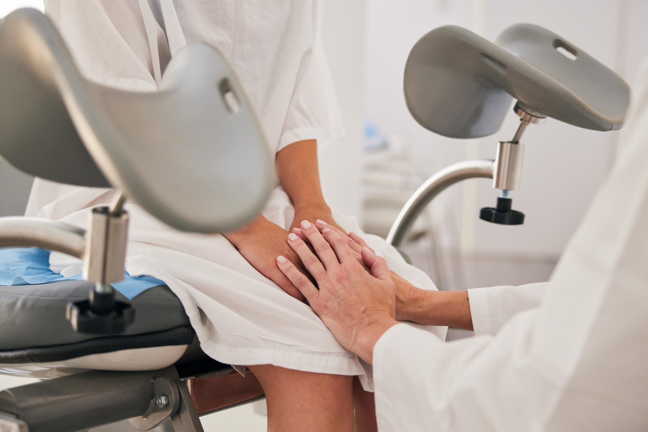 Nő ül a nőgyógyászati vizsgálóágyon.