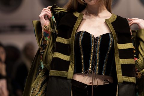 Egy modell a kifutón fűzőt és bársonykabátot visel