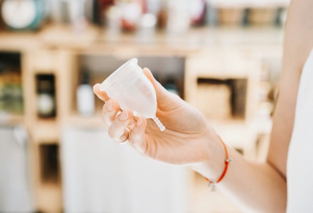 Nő menstruációs kelyhet tart a kezében