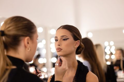 Nő sminkel egy szép fiatal barna hajú lányt