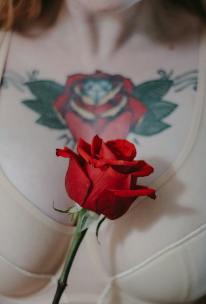 Vörös rózsa tetoválás előtt valódi vörös rózsát fog fehérneműt viselő nő