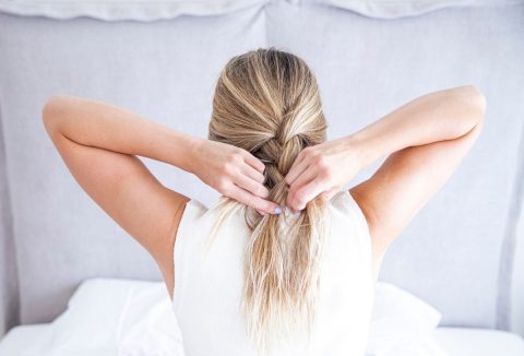 Szőke hajú nő fonja a rövid haját