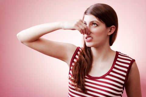 Nő befogja az orrát