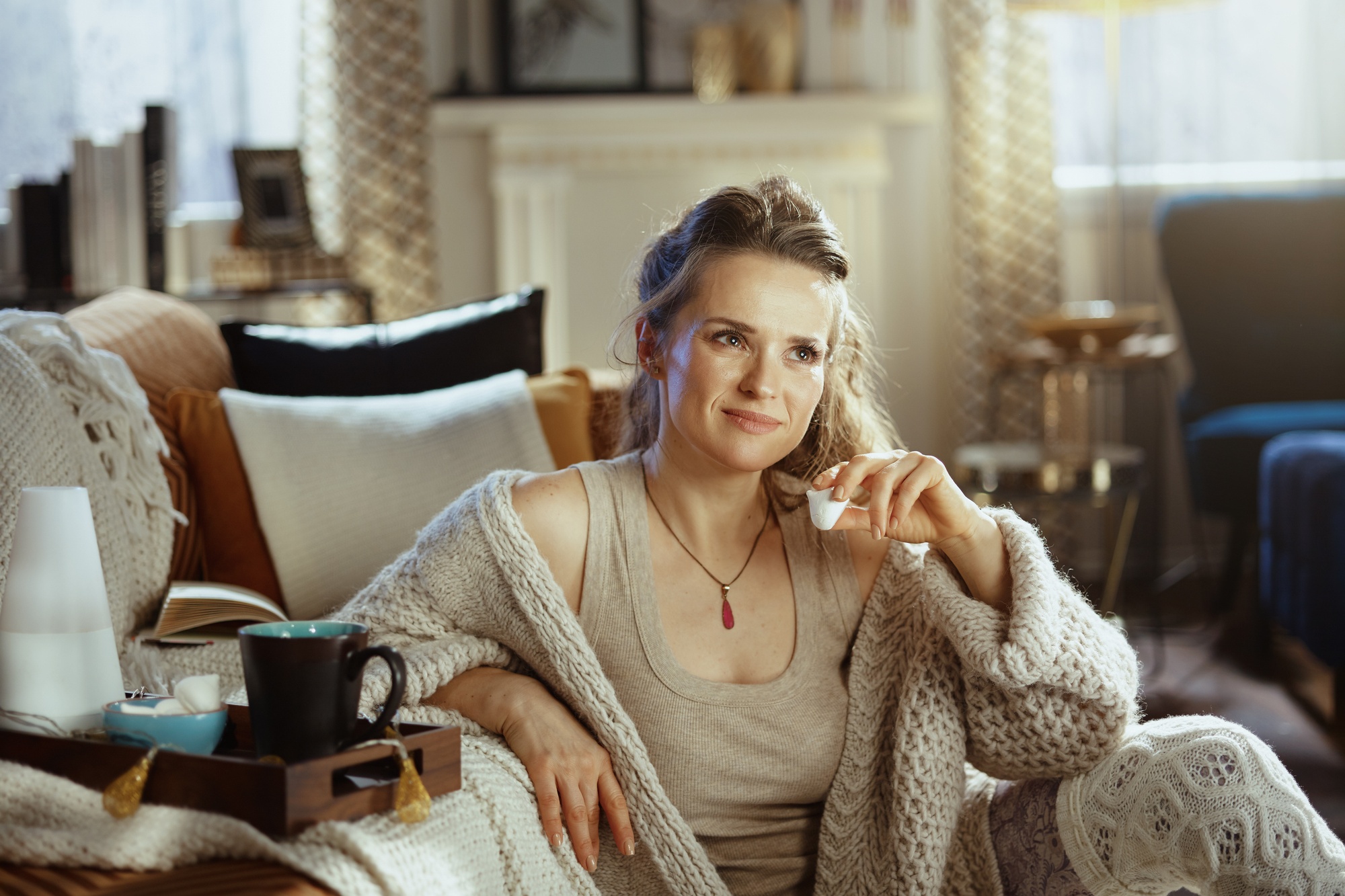 Őszi hangulatú lakásban pihenő nő