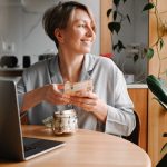 Boldog középkorú nő ül a laptopja előtt