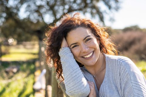 Középkorú nő mosolyog a kamerába