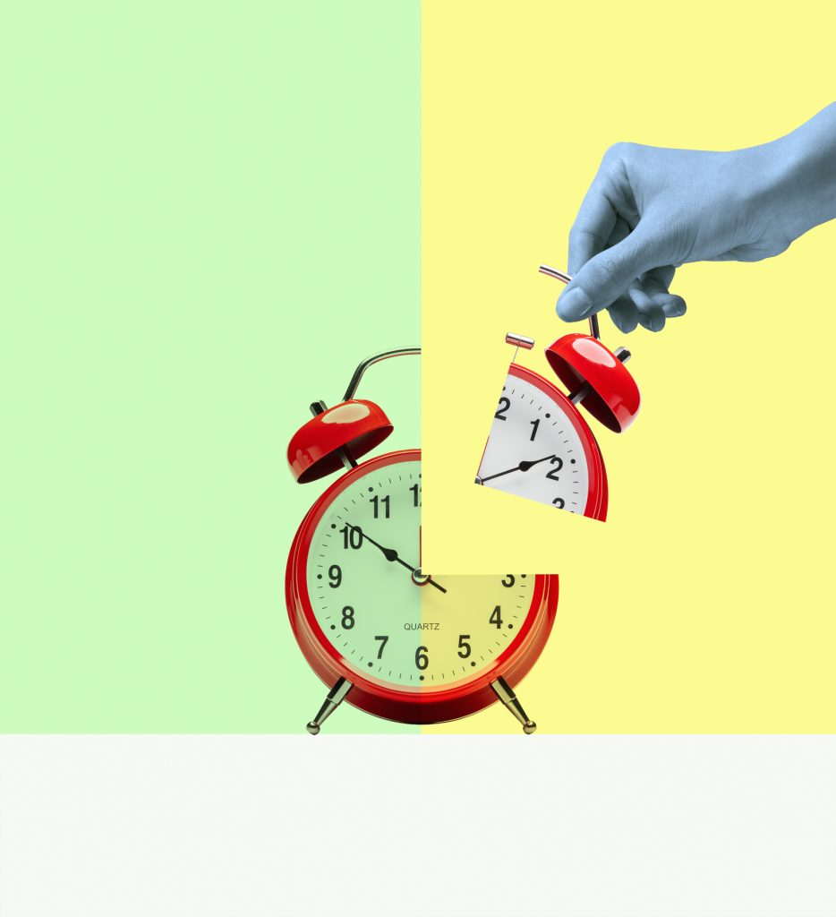 2025-oszi-oraatallitas-ez-lehet-az-utolso | Marie Claire Fekete fehér női kéz tartja egy szabdalt ébresztőóra negyedét