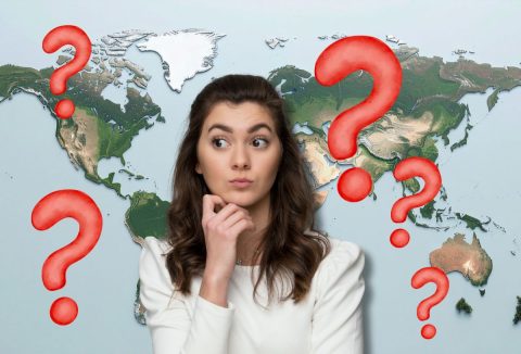 Barna hajú, fiatal lány gondolkodik, háttérben a Föld domborzati térképe, piros kérdőjelek