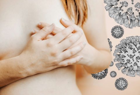 Nő két kezével szorítja a mellét, háttérben koronavírus rajzok