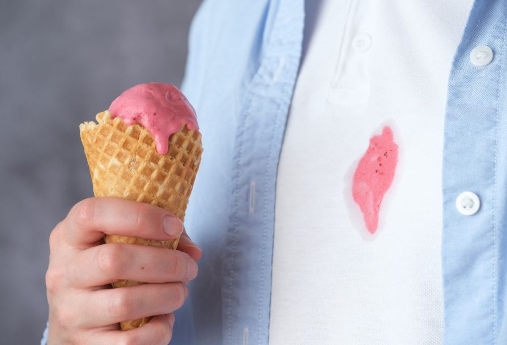 Férfi eperfagyival a kezében, a fehér pólóján fagyifolt