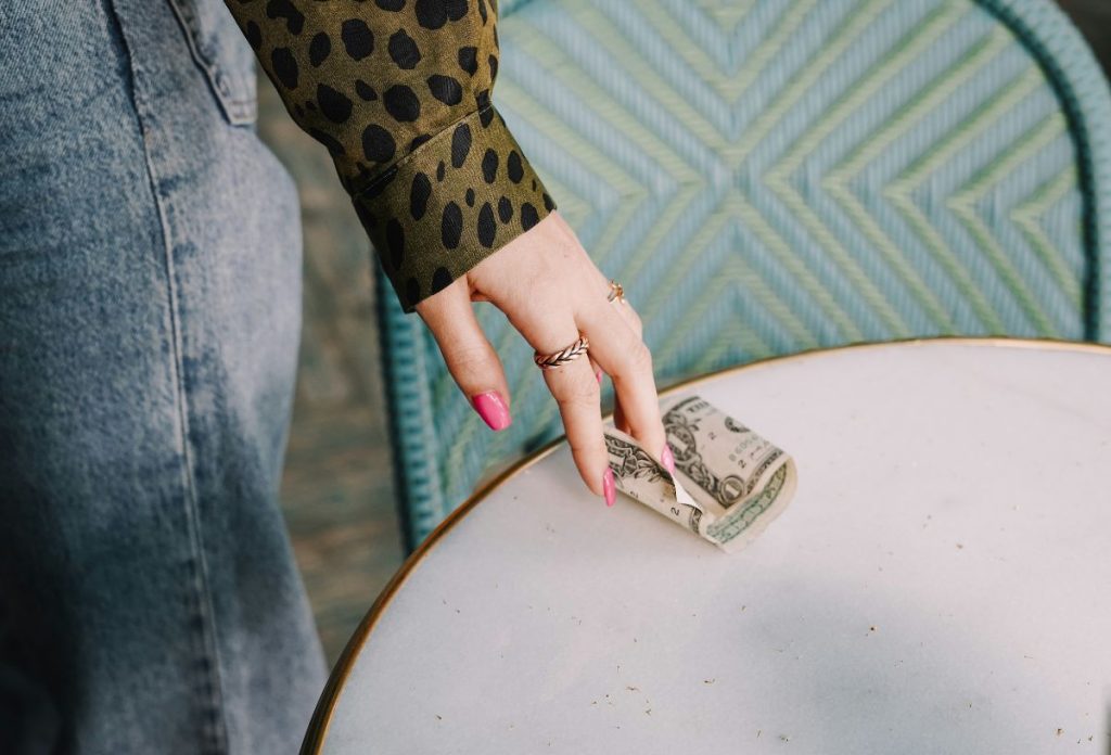 heti-horoszkop-penzugyek-2025-szeptember-8-14 | Marie Claire Női kéz rózsaszín körmökkel, gyűrűkkel, pénzt hagy egy aztalon