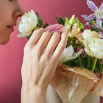 Nő megszagolja a virágcsokrot