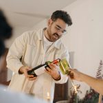 Férfi bort tölt a pohárba