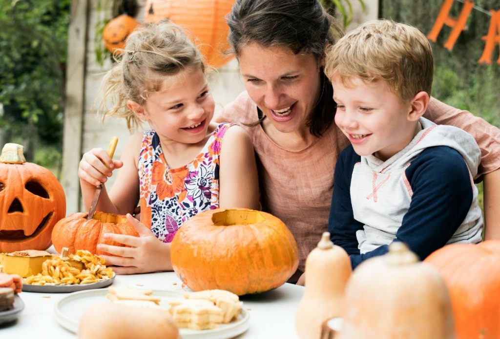 Anyuka és két gyerek közösen halloween tököt farag