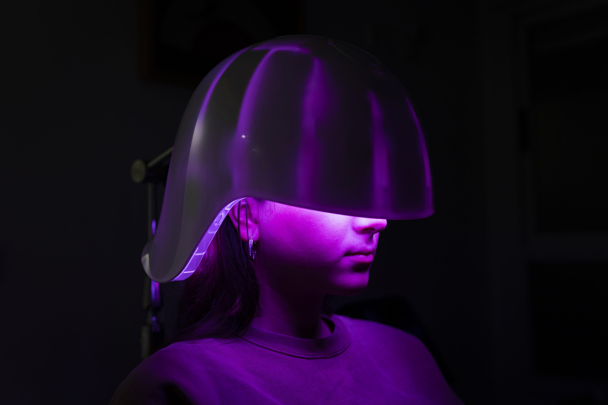 Fiatal nő LED-fényterápiás sisaskban