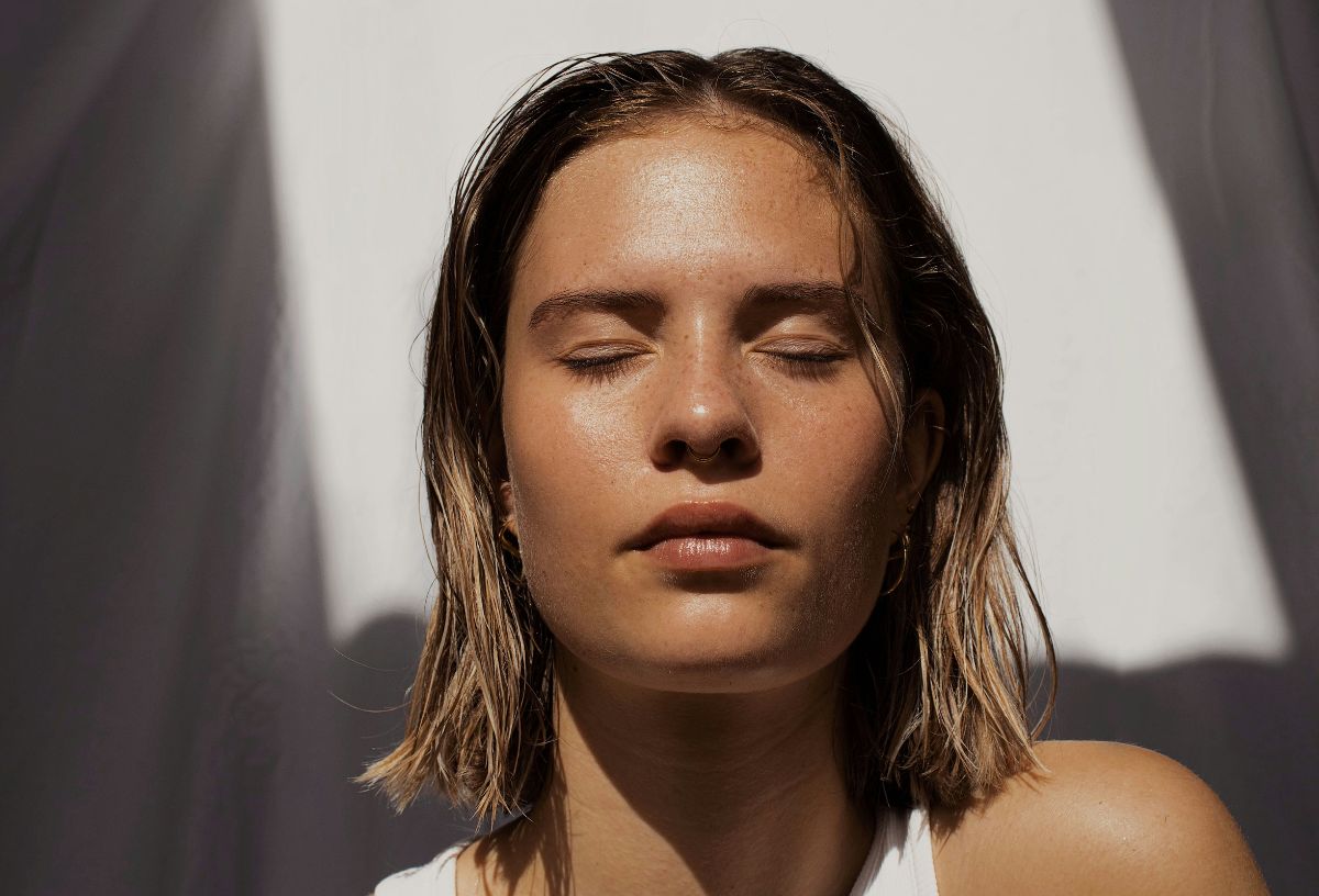 Ragyogó arcbőrű fiatal nő őszi napfényben