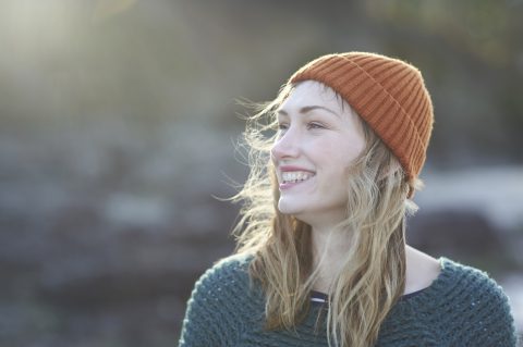 fiatal boldog nő ősszel sapkában