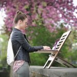 Nő állva dolgozik kültéren