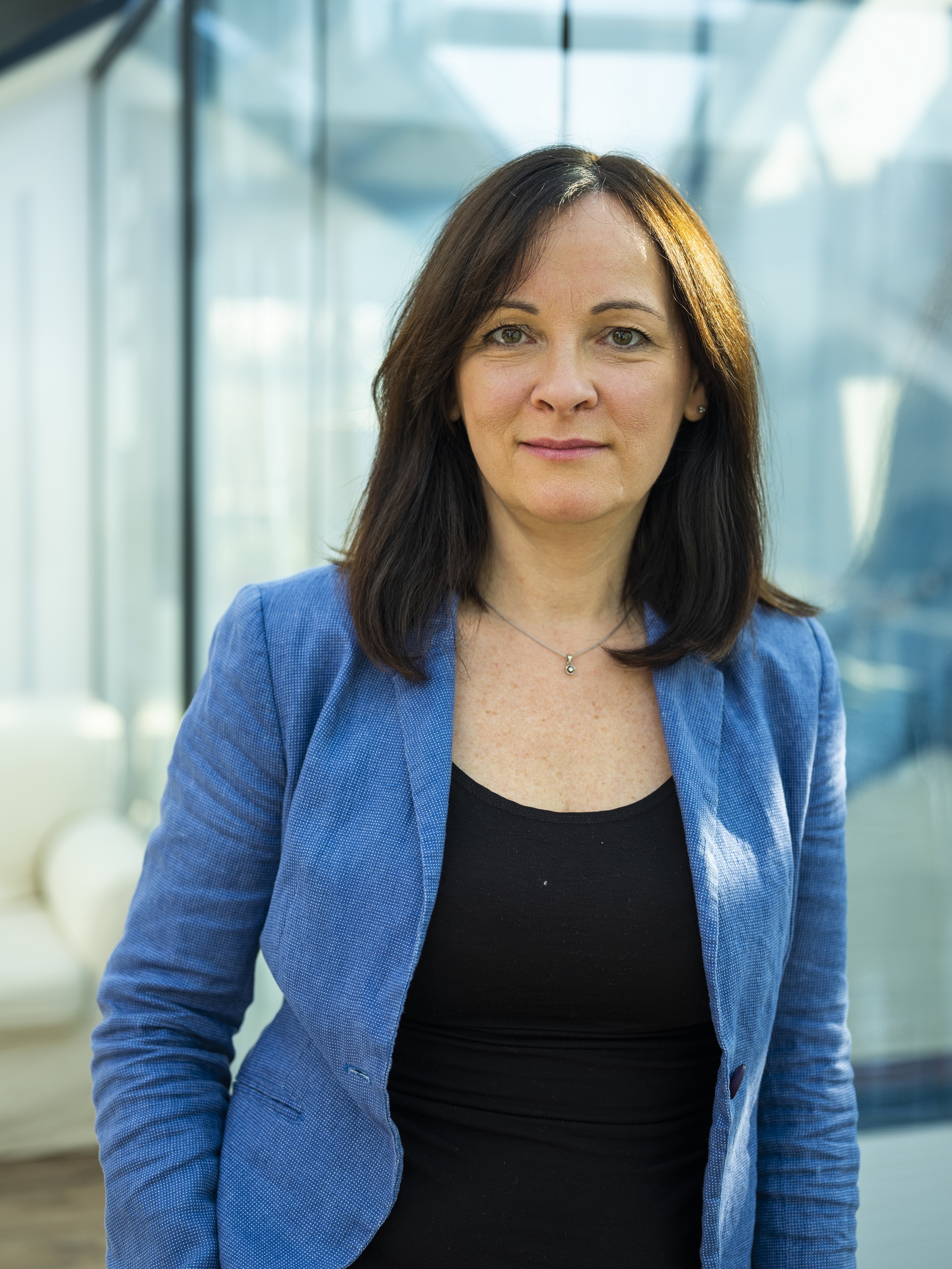 Marton Kriszta kék zakóban a kamerába néz