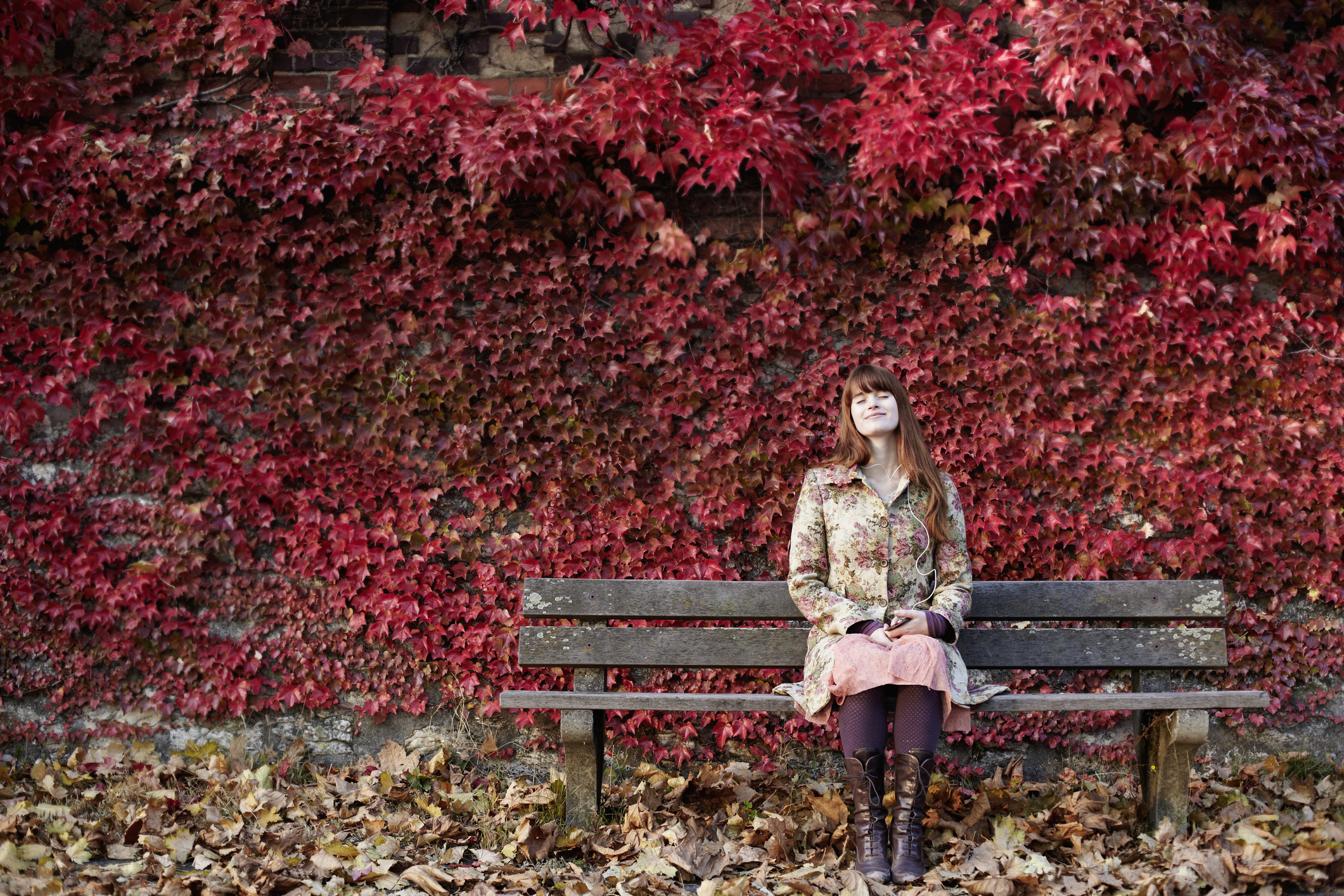 Őszi levelek tövében mosolygó nő