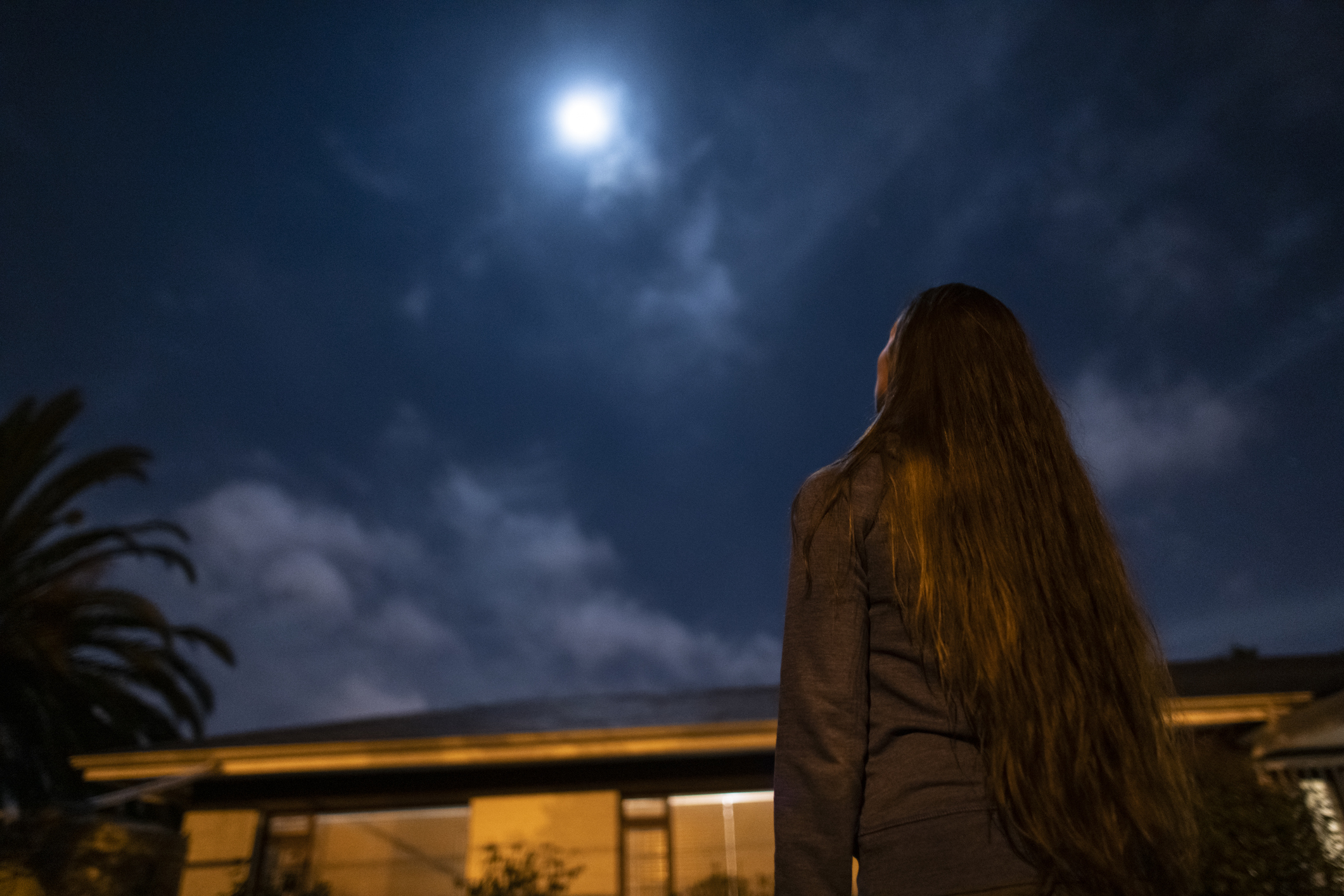 Fiatal nő a teliholdat nézi