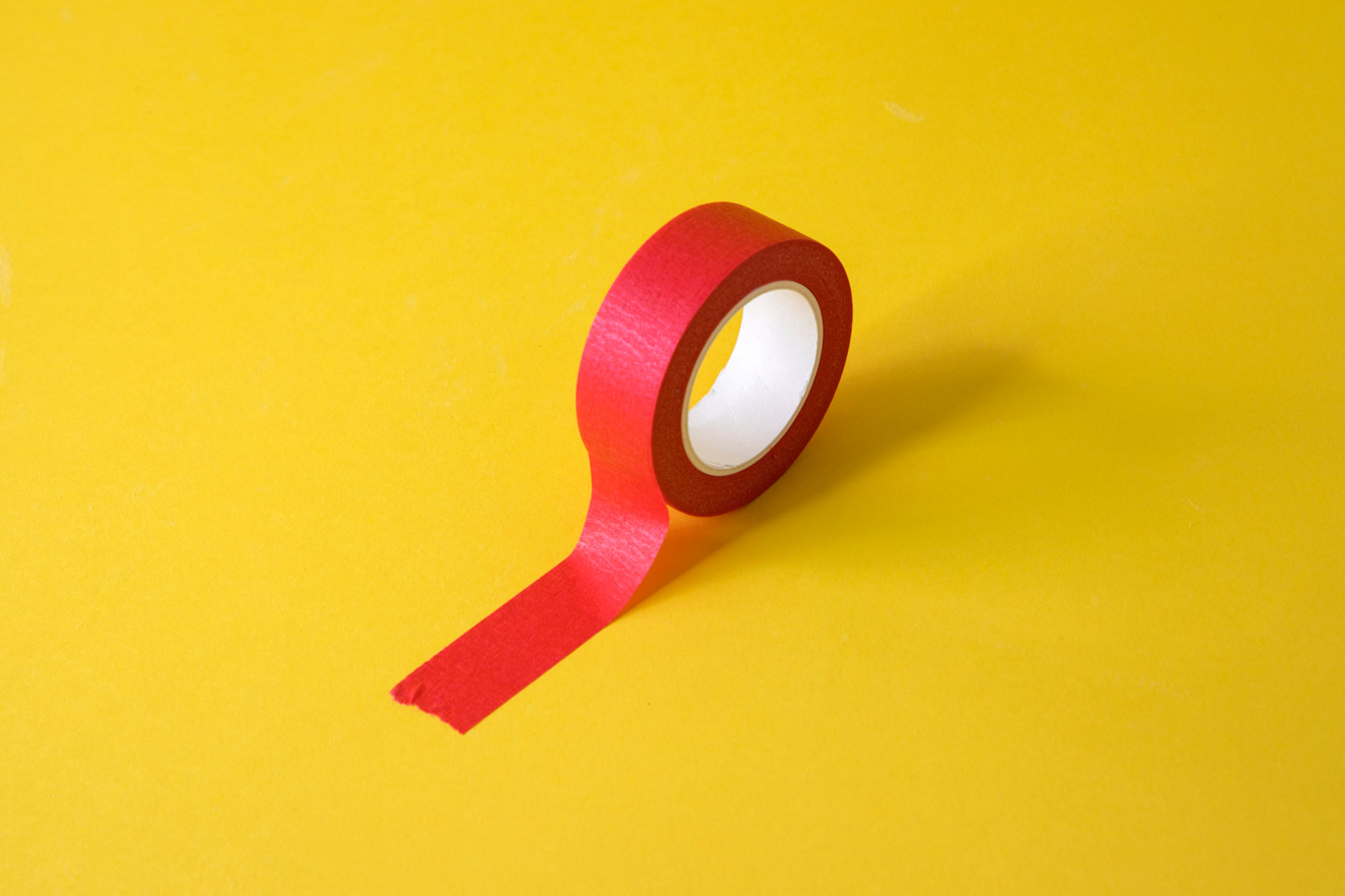 Egy piros ragasztószalag sárga háttéren