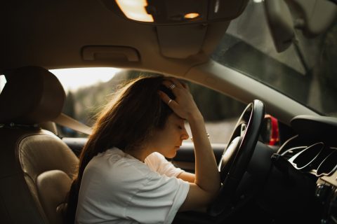 Fiatal nő kiborulva ül az autóban