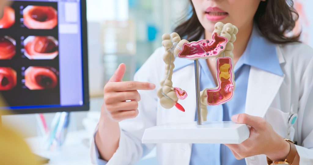 Fiatal gasztroenteorológus a kolonoszkópiát mutatja be egy modellen