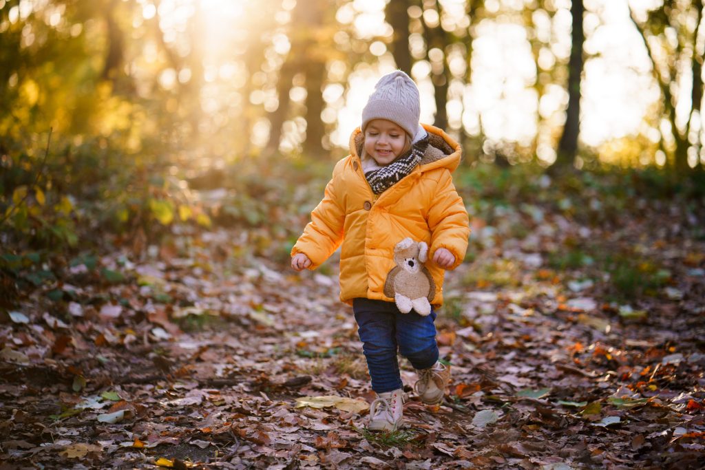 Kislány játszik az őszi avarban
