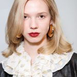 Szőke hajú nő közelről a kamerába néz