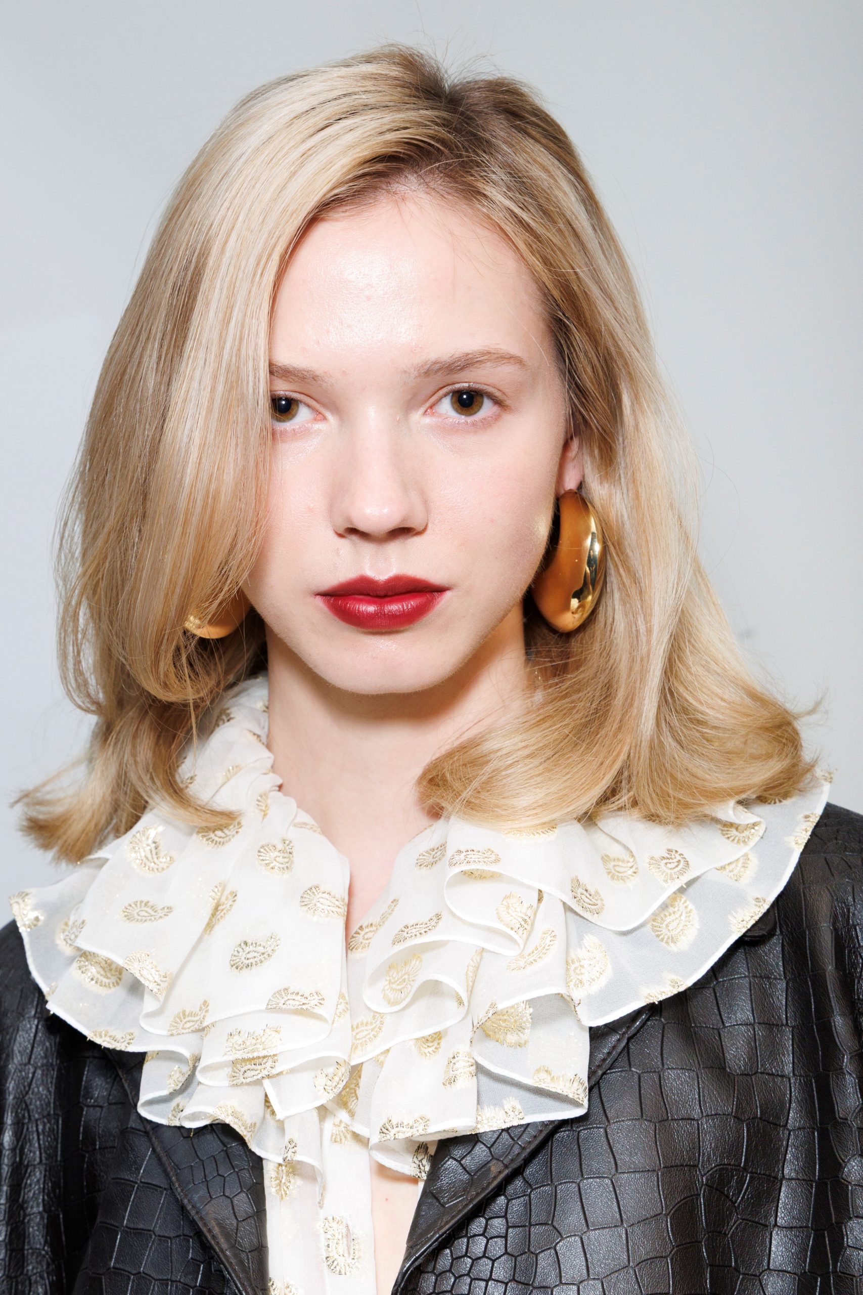 Szőke hajú nő közelről a kamerába néz