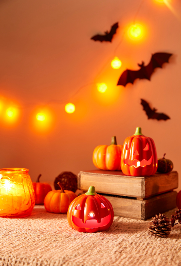 Könyvek és halloween dekoráció tökkel, denevérekkel és fényekkel