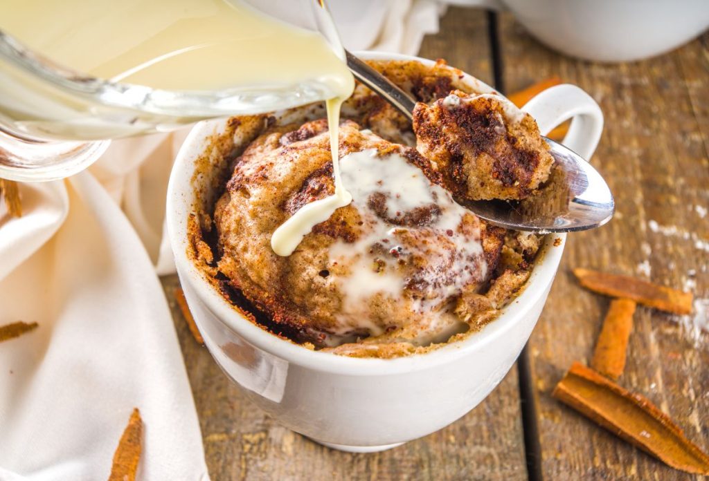 Üvegedényből mázat csorgatnak fahéjas bögrés kuglófra