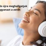 Fiatal nő ellazulva fehér fülhallgatón zenét hallgat boldog arckifejezéssel